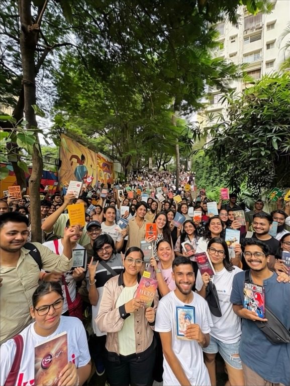 A huge crowd of readers holding up their books, filling The Steps under the trees