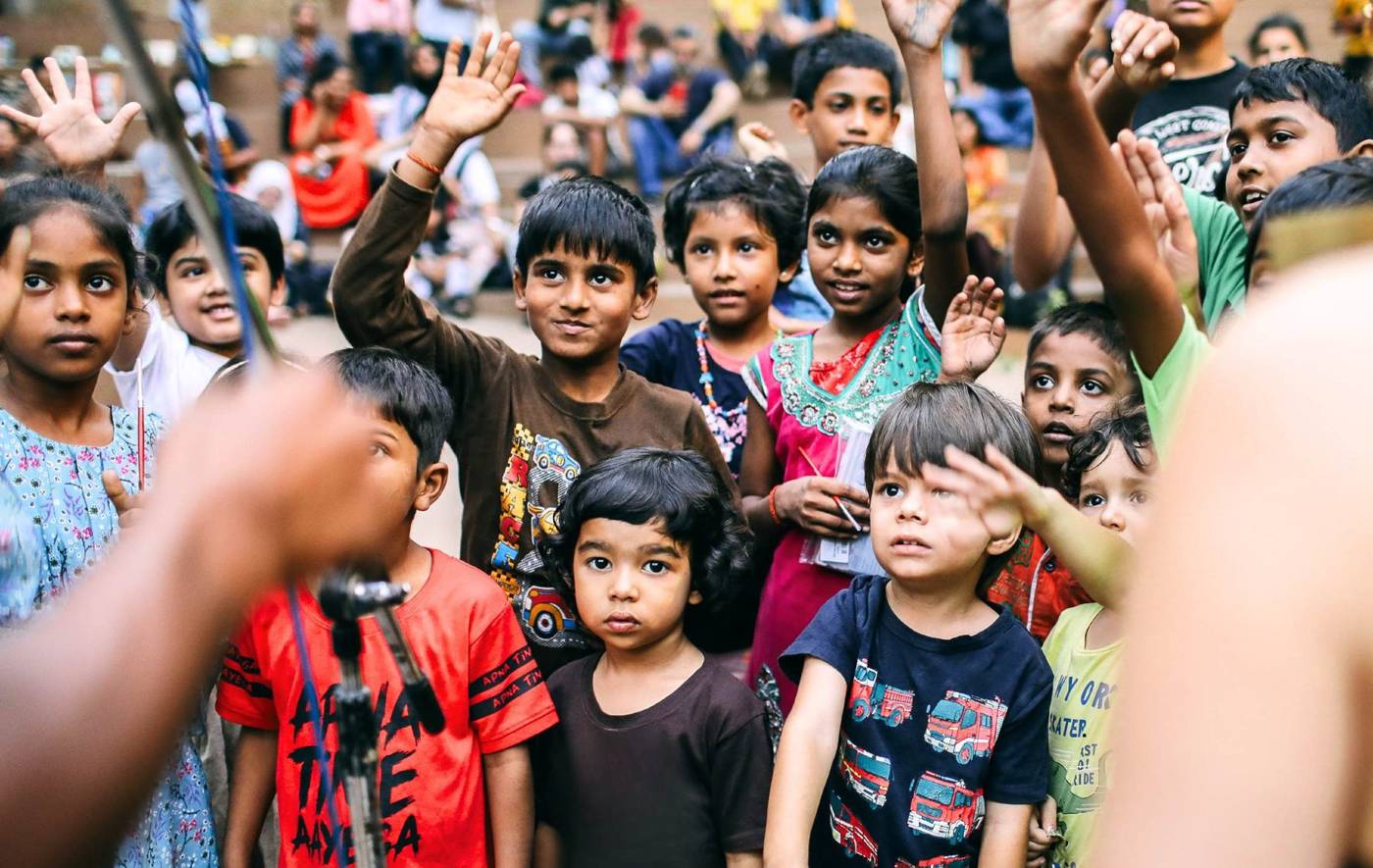 Children in the festival crowd with their hands raised