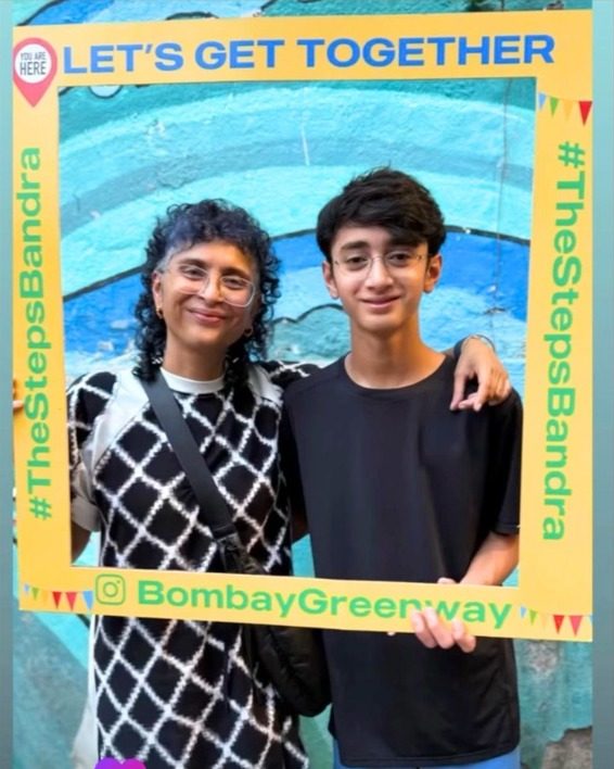 Kiran Rao and her son smiling through a yellow Let's Get Together photo frame at The Steps