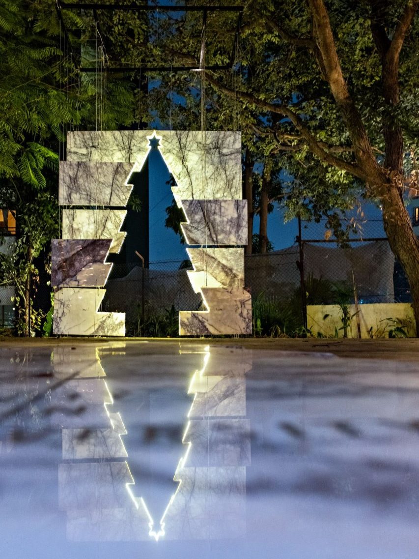 The Unity in Diversity Tree: a Christmas tree cut out of marble slabs, glowing at night